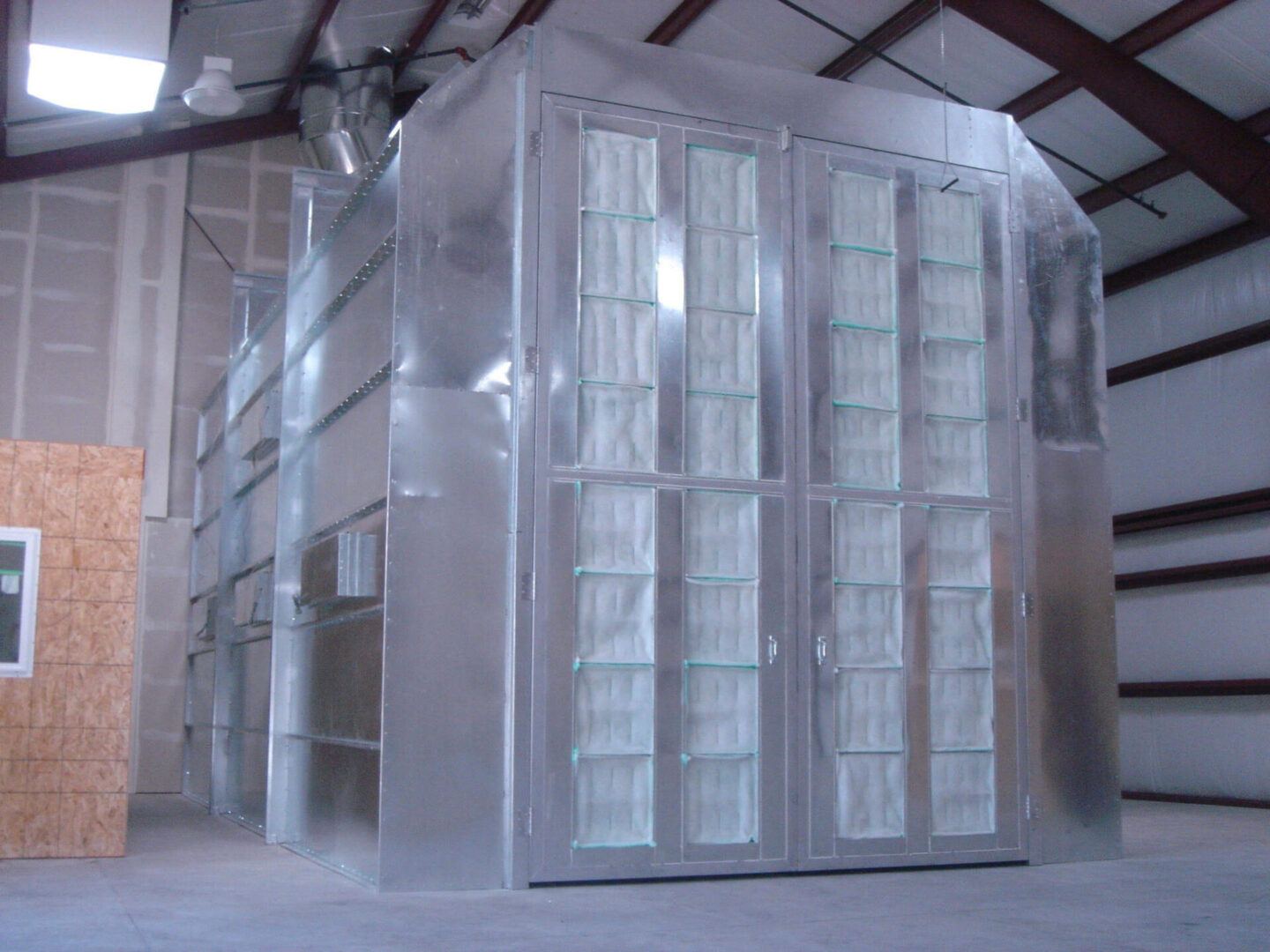 Large industrial walk-in freezer with transparent doors in a warehouse setting.