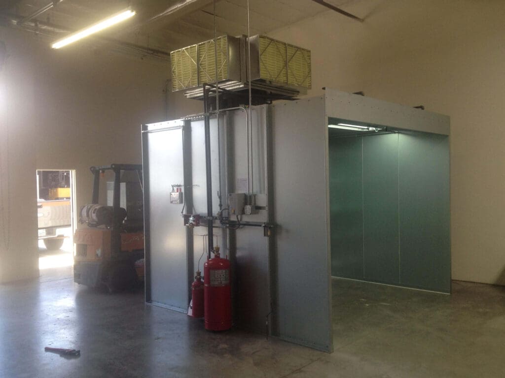 Large industrial freight elevator with open doors in a warehouse, a forklift parked nearby, and a red fire extinguisher on the floor.